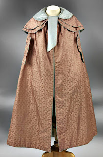 Cloak with capelets, arm slits and piped-bound edgings-front view